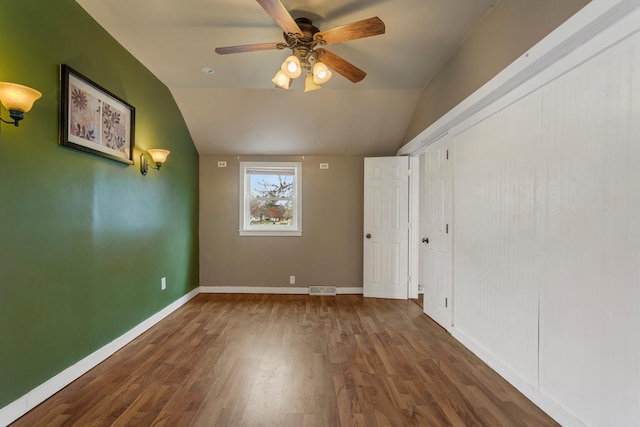 201 S 1st St, Tolono, IL 61880 - unfurnished bedroom featuring wood finished floors, lofted ceiling, baseboards, and ceiling fan