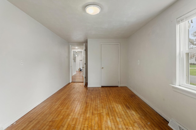 201 S 1st St, Tolono, IL 61880 - unfurnished room featuring light wood-style flooring, plenty of natural light, and baseboards