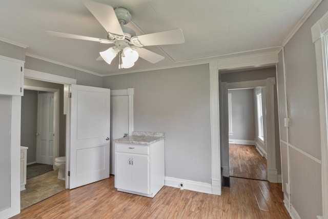 417 E Vermillion St, Odell, IL 60460 - unfurnished bedroom with light wood-style floors, crown molding, baseboards, connected bathroom, and a ceiling fan