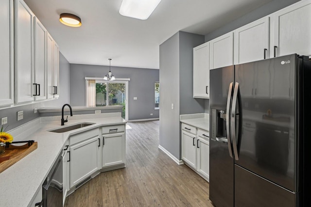 3736 Munson St, Plano, IL 60545 - kitchen with refrigerator with ice dispenser, white cabinets, light wood-type flooring, dishwasher, and a peninsula