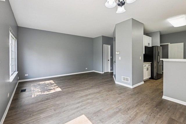 3736 Munson St, Plano, IL 60545 - unfurnished living room with dark wood-style flooring and a chandelier