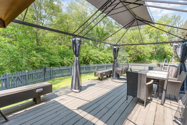2519 Quail Cv, Carpentersville, IL 60110 - wooden deck featuring outdoor dining area, a fenced backyard, and view of scattered trees