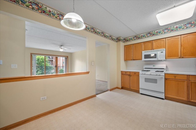455 W Front St Unit 307, Wheaton, IL 60187 - kitchen featuring white appliances, light countertops, brown cabinets, a textured ceiling, and pendant lighting