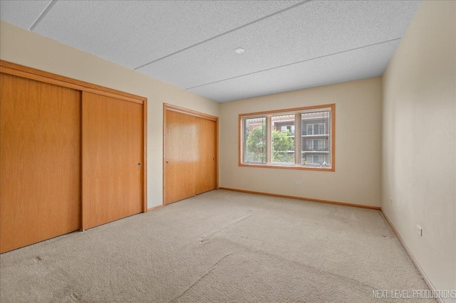 455 W Front St Unit 307, Wheaton, IL 60187 - unfurnished bedroom featuring carpet, two closets, and a textured ceiling