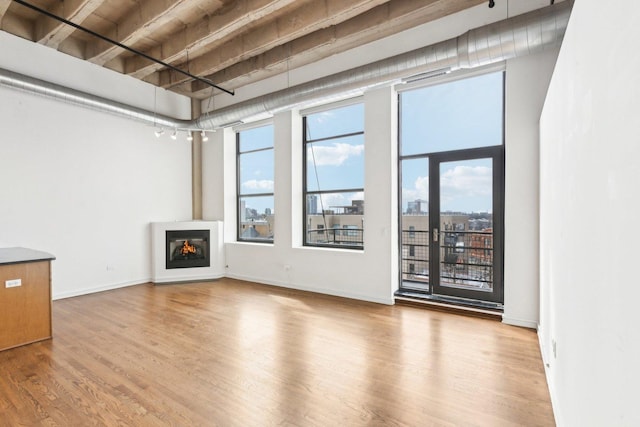 1645 W Ogden Ave Unit 516, Chicago, IL 60612 - unfurnished living room featuring wood finished floors, a glass covered fireplace, and baseboards