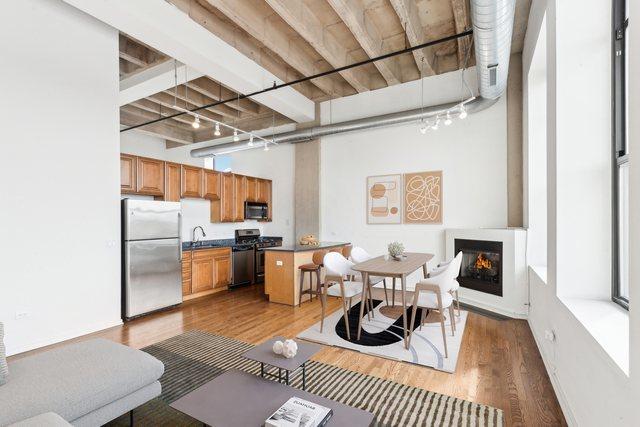 1645 W Ogden Ave Unit 516, Chicago, IL 60612 - dining area with rail lighting, wood finished floors, and a warm lit fireplace