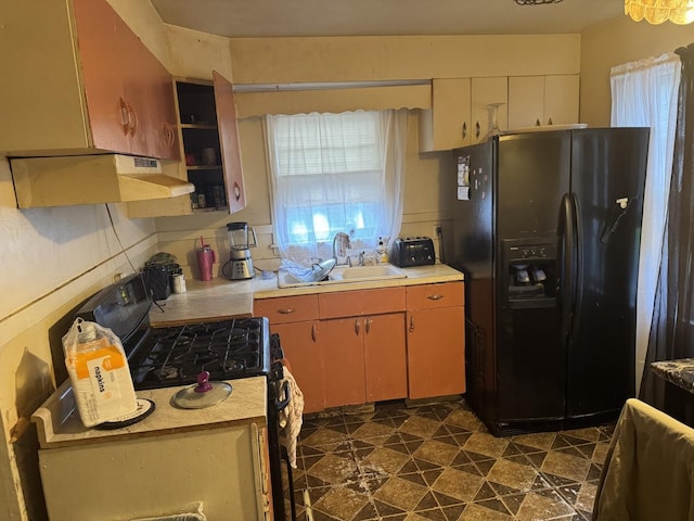 14915 Irving Ave, Dolton, IL 60419 - kitchen featuring black refrigerator with ice dispenser, gas stove, a sink, under cabinet range hood, and light countertops