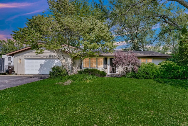 1006 Monroe St, Wauconda, IL 60084 - ranch-style home with an attached garage, asphalt driveway, and a lawn