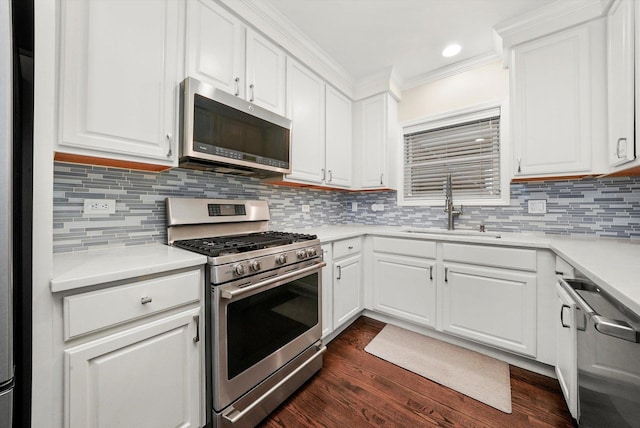 3353 N Kenmore Ave Unit 1, Chicago, IL 60657 - kitchen with appliances with stainless steel finishes, dark wood-type flooring, light countertops, white cabinetry, and crown molding