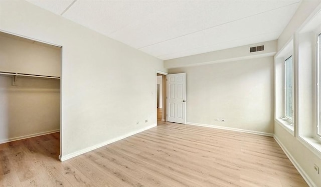 12900 W Heiden Cir Unit 4301, Lake Bluff, IL 60044 - unfurnished bedroom featuring light wood-style flooring, a walk in closet, and a closet