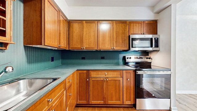 12900 W Heiden Cir Unit 4301, Lake Bluff, IL 60044 - kitchen featuring stainless steel appliances, brown cabinets, light wood finished floors, and light countertops