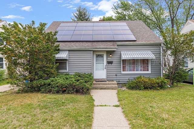 2611 Ellen St, Rockford, IL 61101 - view of front of property featuring a front yard, a shingled roof, solar panels, and a chimney