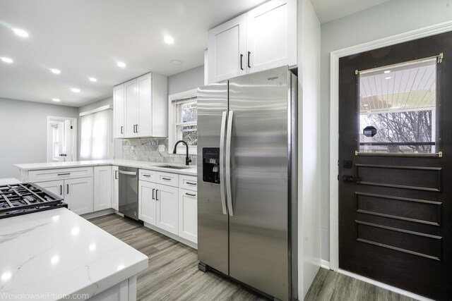 651 Clearmont Dr, Elk Grove Village, IL 60007 - kitchen featuring stainless steel appliances, a sink, white cabinetry, light stone countertops, and tasteful backsplash