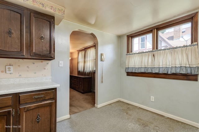371 Elm St, Elgin, IL 60123 - kitchen with arched walkways, light carpet, dark brown cabinets, and light countertops