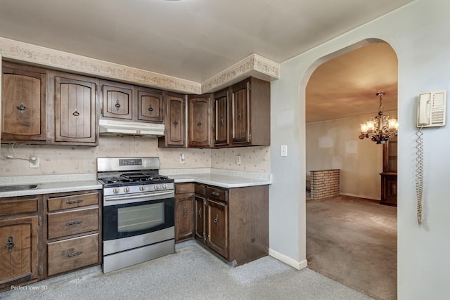 371 Elm St, Elgin, IL 60123 - kitchen with gas range, under cabinet range hood, arched walkways, light carpet, and a chandelier