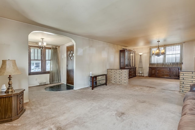 371 Elm St, Elgin, IL 60123 - unfurnished living room with a chandelier, arched walkways, and carpet floors