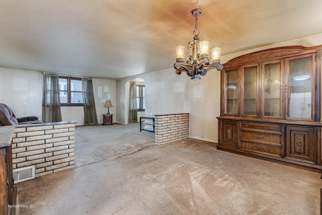 371 Elm St, Elgin, IL 60123 - unfurnished dining area with arched walkways, light colored carpet, and a chandelier