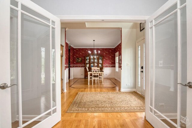 141 Mary Hamsmith Ct, Sycamore, IL 60178 - foyer entrance featuring wallpapered walls, wood finished floors, french doors, ornamental molding, and wainscoting