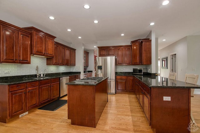 141 Mary Hamsmith Ct, Sycamore, IL 60178 - kitchen with appliances with stainless steel finishes, light wood-style flooring, a sink, backsplash, and a peninsula