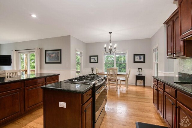 141 Mary Hamsmith Ct, Sycamore, IL 60178 - kitchen featuring stainless steel range with gas stovetop, a chandelier, plenty of natural light, light wood finished floors, and wainscoting
