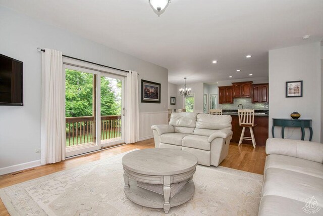141 Mary Hamsmith Ct, Sycamore, IL 60178 - living room featuring a chandelier, healthy amount of natural light, light wood-style flooring, recessed lighting, and wainscoting