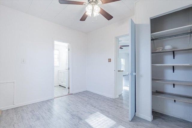 800 E Webster St, Clinton, IL 61727 - unfurnished bedroom with wood finished floors, ceiling fan, connected bathroom, baseboards, and a closet