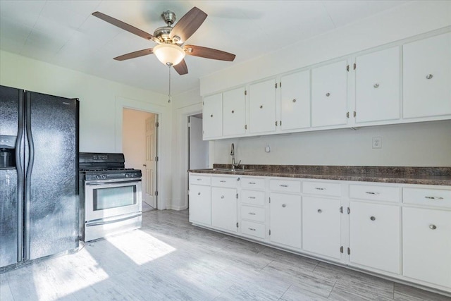 800 E Webster St, Clinton, IL 61727 - kitchen featuring stainless steel gas range oven, black fridge, white cabinetry, and dark countertops