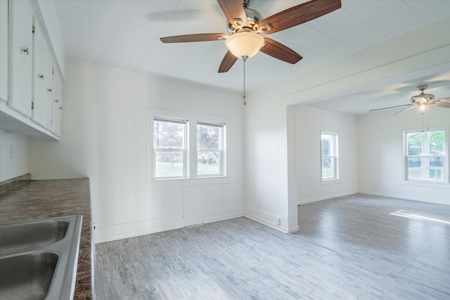 800 E Webster St, Clinton, IL 61727 - unfurnished dining area featuring a ceiling fan, light wood-type flooring, a sink, and baseboards