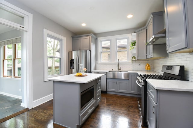 1234 Edmer Ave, Oak Park, IL 60302 - kitchen featuring gray cabinetry, stainless steel appliances, wall chimney exhaust hood, dark wood-style flooring, and recessed lighting