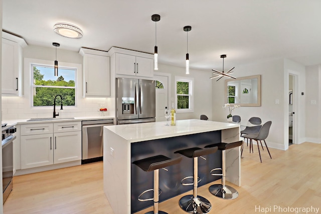 539 S Plum Grove Rd, Palatine, IL 60067 - kitchen with appliances with stainless steel finishes, a sink, light wood finished floors, and tasteful backsplash