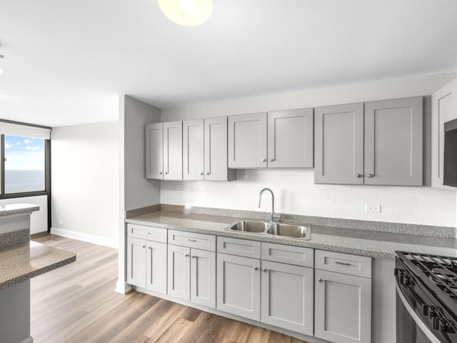 4850 S Lake Park Ave Unit 2508B, Chicago, IL 60615 - kitchen with gray cabinetry, light wood-style floors, backsplash, and range with gas cooktop