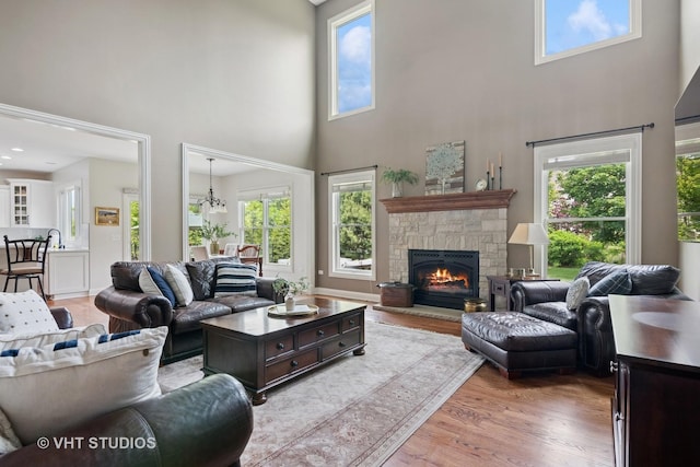76 Landon Cir, Wheaton, IL 60189 - living room featuring a towering ceiling, a stone fireplace, and wood finished floors