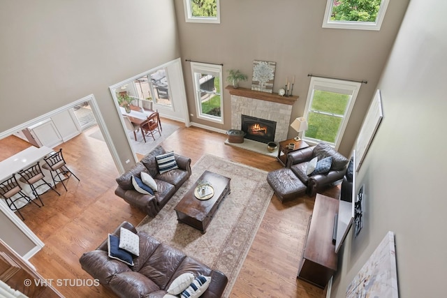 76 Landon Cir, Wheaton, IL 60189 - living room featuring a high ceiling, a stone fireplace, and wood finished floors
