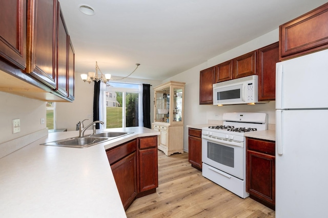 6941 Brightwater Dr, Fox Lake, IL 60020 - kitchen with white appliances, light wood-style floors, light countertops, a chandelier, and a peninsula