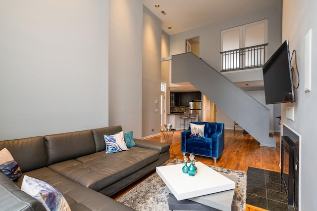 2943 N Lincoln Ave Unit 201, Chicago, IL 60657 - living area with baseboards, a towering ceiling, stairway, a fireplace with flush hearth, and wood finished floors