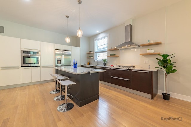 2414 W Grenshaw St Unit 1E, Chicago, IL 60612 - kitchen featuring wall chimney range hood, open shelves, stainless steel appliances, dark brown cabinets, and light wood-style floors