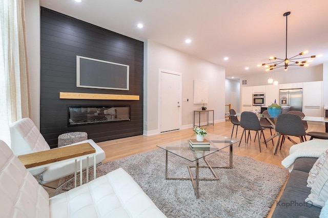 2414 W Grenshaw St Unit 1E, Chicago, IL 60612 - living area featuring light wood-style flooring, recessed lighting, a fireplace, and a chandelier