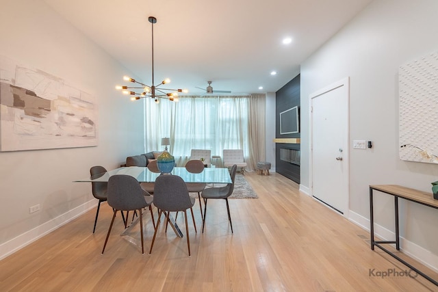 2414 W Grenshaw St Unit 1E, Chicago, IL 60612 - dining area featuring light wood-type flooring, a large fireplace, recessed lighting, a ceiling fan, and a chandelier