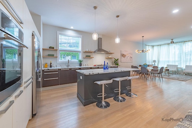 2414 W Grenshaw St Unit 1E, Chicago, IL 60612 - kitchen featuring wall chimney exhaust hood, open shelves, stainless steel appliances, light wood-type flooring, and a kitchen breakfast bar