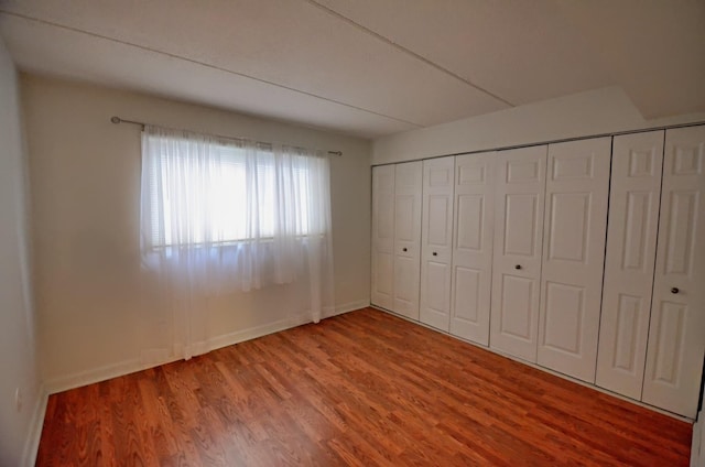 5848 W 76th Pl Unit 202, Burbank, IL 60459 - unfurnished bedroom featuring wood finished floors, baseboards, and a closet
