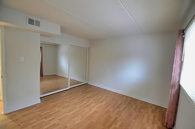 5848 W 76th Pl Unit 202, Burbank, IL 60459 - unfurnished bedroom with light wood-style floors, baseboards, and a closet