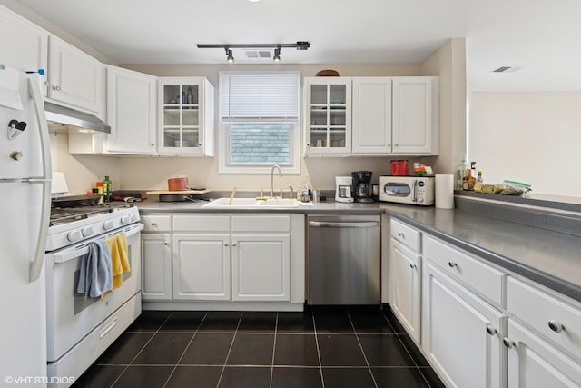 1140 W Barry Ave, Chicago, IL 60657 - kitchen featuring stainless steel appliances, under cabinet range hood, dark tile patterned floors, white cabinetry, and glass insert cabinets