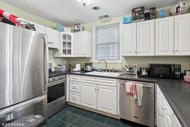 1140 W Barry Ave, Chicago, IL 60657 - kitchen featuring appliances with stainless steel finishes, dark countertops, white cabinetry, under cabinet range hood, and glass insert cabinets