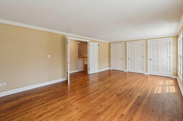 21956 N Hickory Hill Dr, Kildeer, IL 60047 - unfurnished bedroom with multiple closets, wood finished floors, baseboards, and crown molding