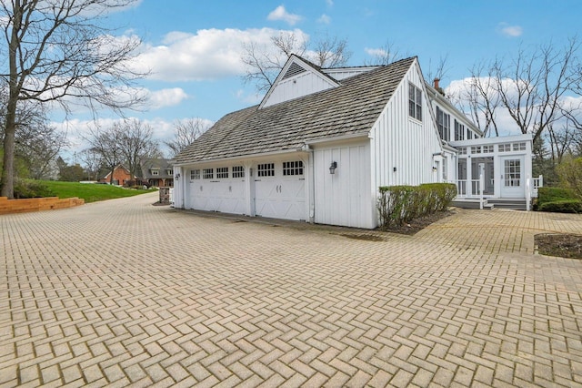 21956 N Hickory Hill Dr, Kildeer, IL 60047 - view of property exterior with board and batten siding, decorative driveway, a chimney, an attached garage, and a sunroom