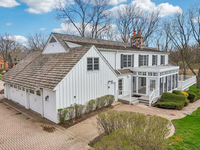 21956 N Hickory Hill Dr, Kildeer, IL 60047 - view of side of property with a sunroom, board and batten siding, a garage, and a chimney