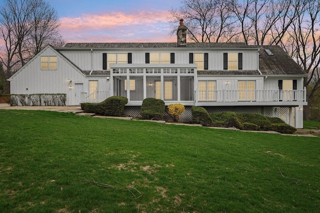 21956 N Hickory Hill Dr, Kildeer, IL 60047 - rear view of property with board and batten siding, a sunroom, a chimney, a yard, and a wooden deck