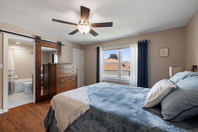 16906 Grissom Dr, Tinley Park, IL 60477 - bedroom featuring a barn door, wood finished floors, ceiling fan, and ensuite bathroom