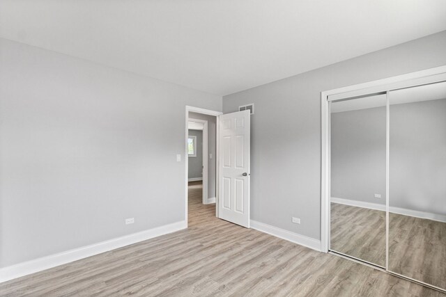 15240 Woodlawn Ave, Dolton, IL 60419 - unfurnished bedroom featuring wood finished floors, a closet, and baseboards