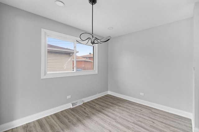 15240 Woodlawn Ave, Dolton, IL 60419 - unfurnished room with a chandelier, wood finished floors, and baseboards